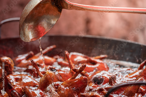 Obraz na plátně cooking traditional soy sauce duck in brine pot pouring savory marinade