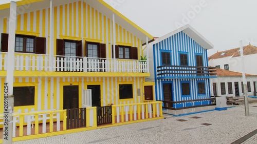 A slow panning shot showing the famous traditional colorful striped houses on the coast of Costa Nova, Aveiro in Portugal. 24.05.2026