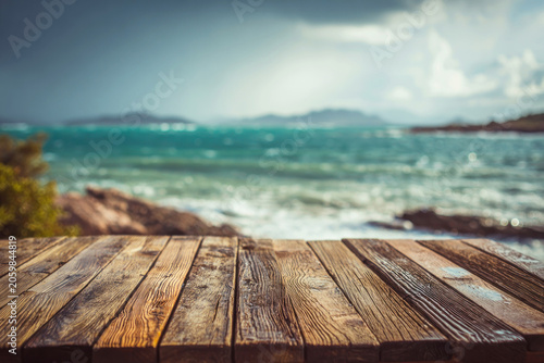 Empty wooden table top with beautiful beach and ocean under soft afternoon sunlight