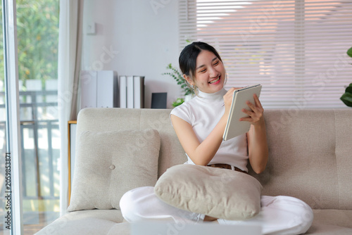 Photography Asian woman feeling creative and inspired while writing in a notebook, smiling a