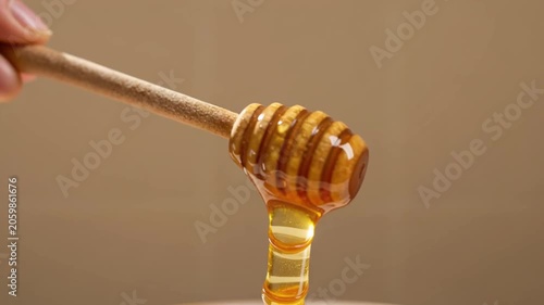 honey dripping from a wooden dipper