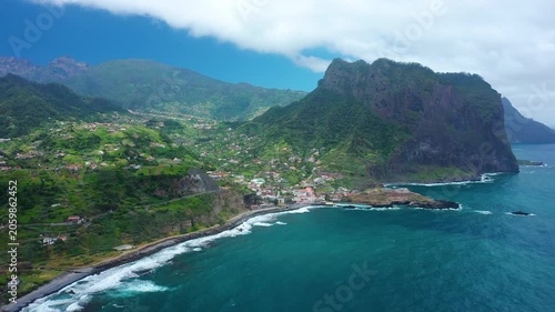 Spectacular coastal view of the majestic Penha d'Aguila rock mountain rising over the blue sea bay of Porto da Cruz, Madeira, Portugal.