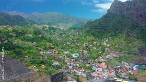 Spectacular coastal view of the majestic Penha d'Aguila rock mountain rising over the blue sea bay of Porto da Cruz, Madeira, Portugal.