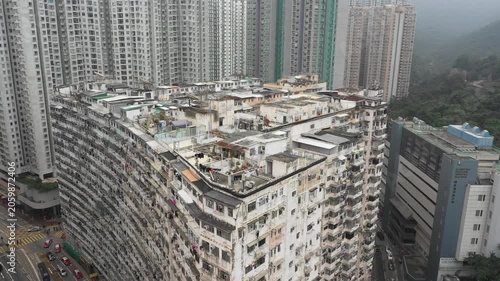 Hong Kong housing market crisis - Ascending drone shot of illegal small houses built on top of government subsidized apartment complex