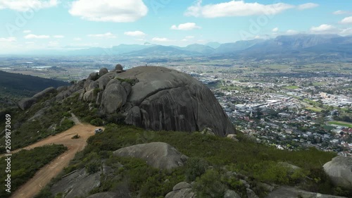 Fly over Paarl Rock granite outcrop and reveal town of Paarl below