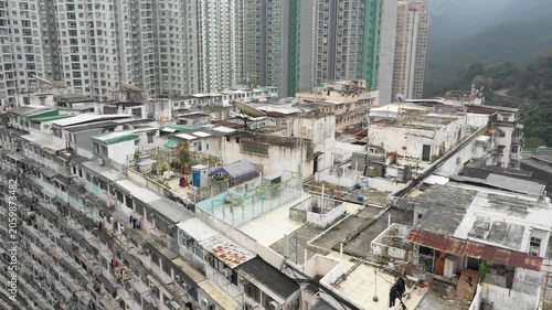 Hong Kong contrast - drone shot past old government subsidized housing complex with modern residential building in the background