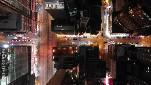 Drone shot of busy illuminated streets with pedestrians and traffic in Kowloon, Hong Kong