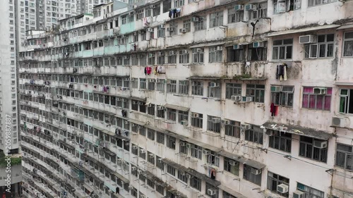 Drone flight past windows, laundry, and air conditioning systems of small apartment buildings in old residential neighborhood of Hong Kong island