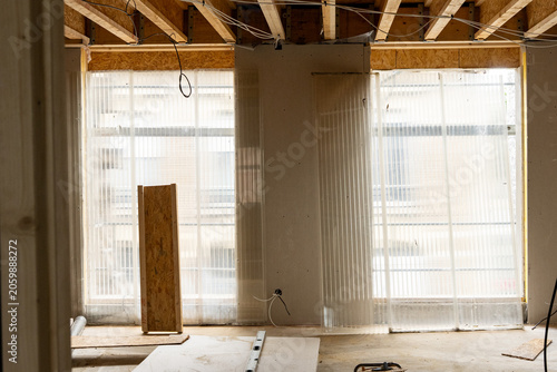 Fotografía Intérieur d’un espace en travaux avec matériaux de construction, outils et surfaces inachevées illustrant un chantier en cours de rénovation ou d’aménagement