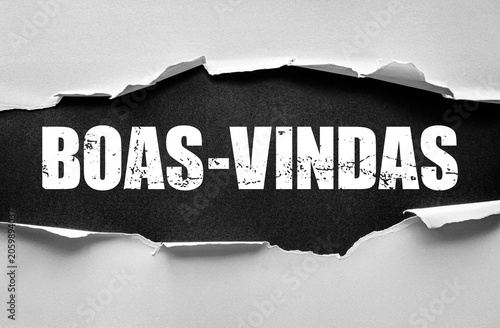 Photography Torn paper reveals the bold grunge word BOAS-VINDAS underneath, symbolizing welc