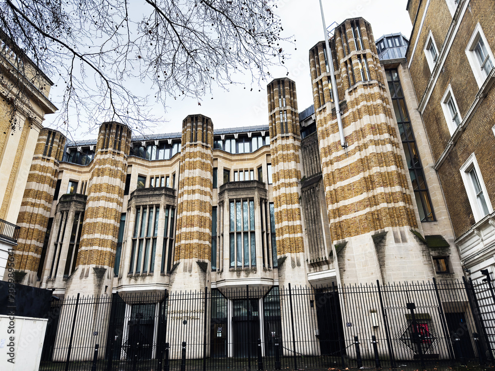 Naklejka premium Historic striped brick civic Richmond House building with tall columns and gated facade in London, UK city center