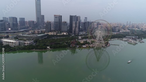 Drone flight towards ferris wheel and commercial district of Suzhou city in China