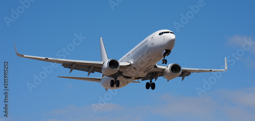 The plane lands. Airplane, passengers flying in the blue sky, preparing to land at the airport