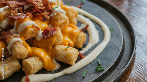 Foto Cheesy loaded tater tots with bacon and sour cream, rustic skillet appetizer, co