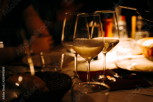 Tableau sur toile Glasses of white wine adorn a table during an elegant candlelight dinner