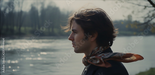 French-style romantic portrait of a young man by the riverside, evoking timeless Parisian cinema aesthetics, soft melancholy, and poetic vintage elegance.