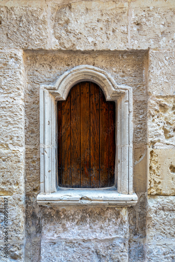 Fototapeta premium close up of wooden hatch in rabat, Mdina, Malta used in history to dispose of children shot in summer sunlight