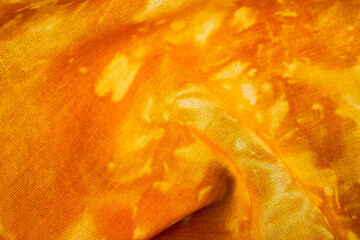 Close up of orange tie dye fabric texture
