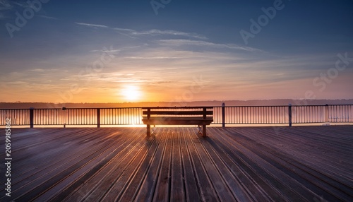 Empty Bench At The End Of The Pier At Sunrise
