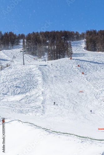 Skiers on a snowy slope in bright winter sun