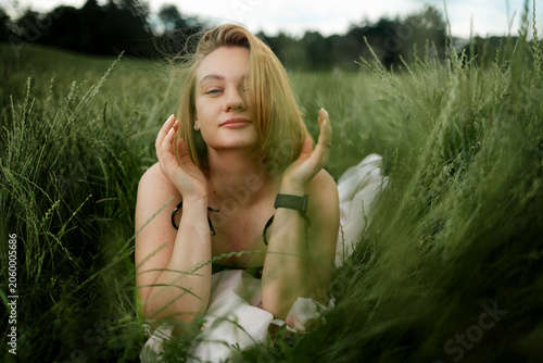 Schilderij op canvas Blue-eyed blonde lying on the grass