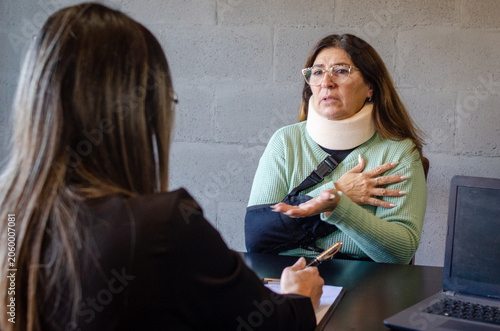 Injured senior woman explaining accident details to personal injury attorney