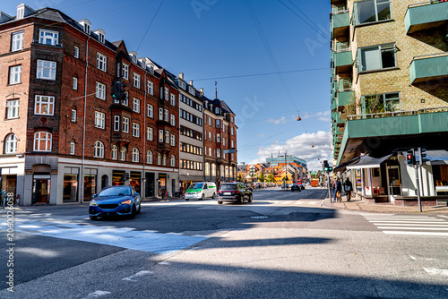 Foto Traffic at an intersection in Copenhagen on sunny day with people and cars, Christianshavn district, street life in Denmark