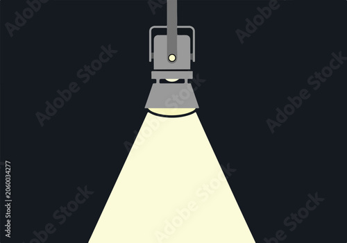 A spotlight shines down with a dark background