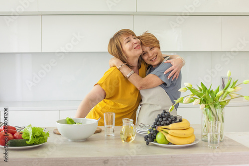 Loving female couple cooking talking and having fun together on kithen at home. Healthy woman person indoor lifestyle portrait