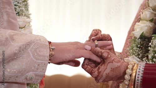 Close-up of an Indian Bride withI intricate Mehndi Putting a Wedding Ring on the Groom's Finger
