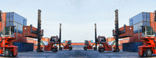 Red container handlers operate heavy-duty equipment moving cargo containers at busy port under expansive blue sky  showcasing powerful logistics and global trade operations..