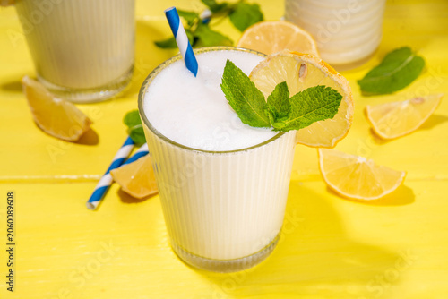 Whipped lemonade or mojito cocktail, lemonade milkshake. Italian summer alcoholic cocktail Sgroppino. Viral Brazilian lemonade. Two servings in glasses and jar, with fresh lemons and mint