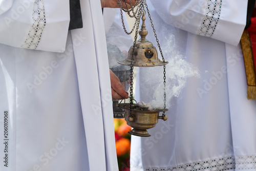 Priest holding censer thurible with rising smoke