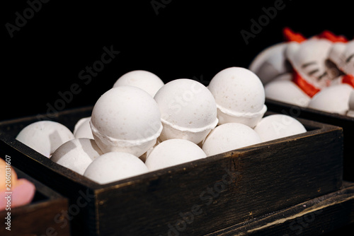Colorful bath bombs arranged on a store display shelf. Handmade bath products with vibrant colors used for relaxation, spa and self care routines in a retail environment.
