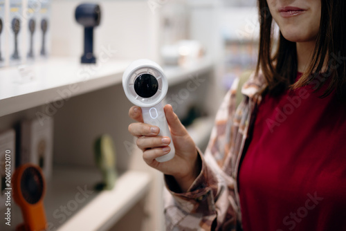 Woman selecting a portable mini fan in a retail store.