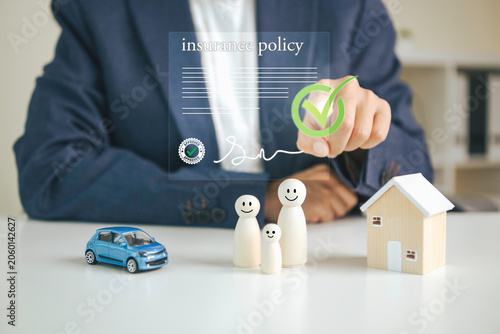 Foto Insurance policy approval with family home and vehicle models illustrating compr