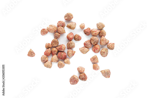 Treated spinach seeds scattered on a white background. Top view of pink coated vegetable seeds ready for agricultural planting