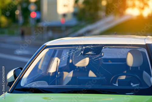Foto Parked car with broken windshield glass with spiderweb cracks spreading from impact point, auto repair, replacement service needed, vehicle damage and transportation safety concern
