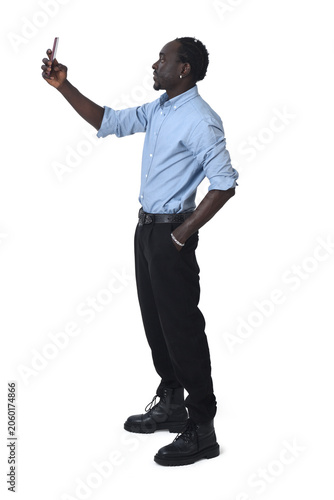 Vászonkép side view of a man taking a self-portrait on white background