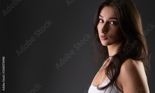 Elegant young woman posing for a fashion portrait with a dark background