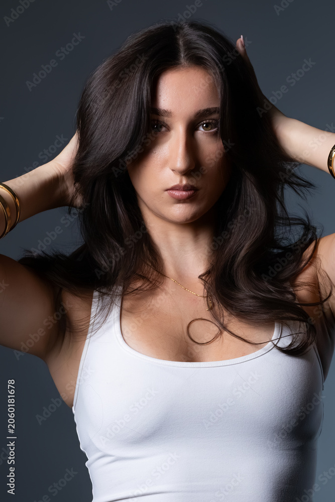 Naklejka premium Female model highlighting beauty and confidence with a stylish pose in studio