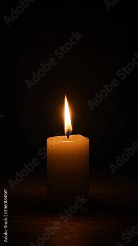 Single candle burning against a dark background. Hope, remembrance, spirituality and peaceful reflection concept.