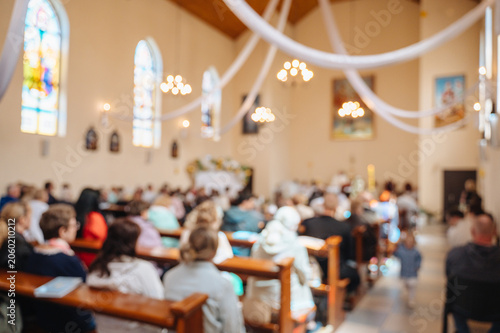 Tableau sur toile Blurred atmospheric photo of parishioners praying inside a cathedral, faith and