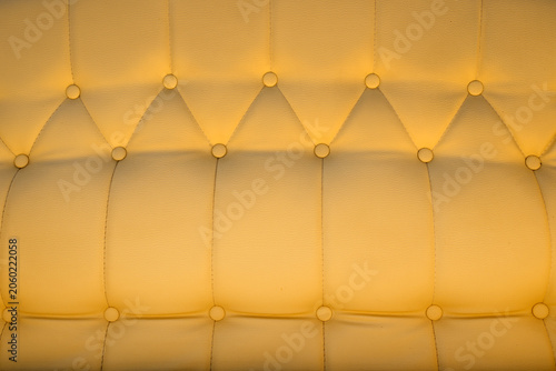 Konstfotografi Soft yellow tufted leather upholstery with buttoned padding and stitched seams,