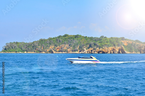 The speedboat sailing in the deep blue sea combined with the beautiful view of the sky.
