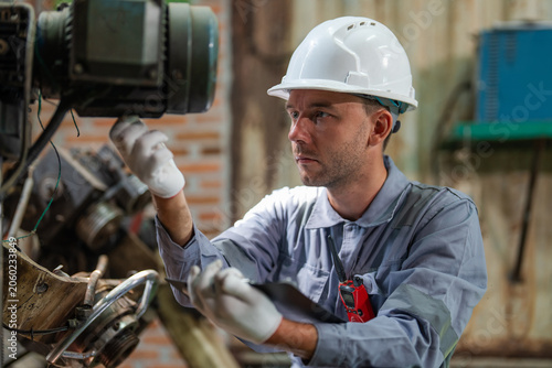Foto Man wears a white hard hat and blue work shirt