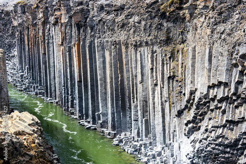 Konstfotografi Basalt columns at Studlagil Canyon with green river water in East Iceland