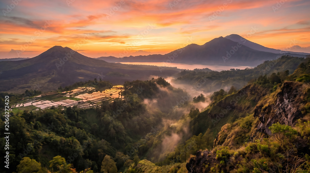 Obraz premium Golden Sunrise Over Mountain Valley With Mist and Dramatic Natural Landscape