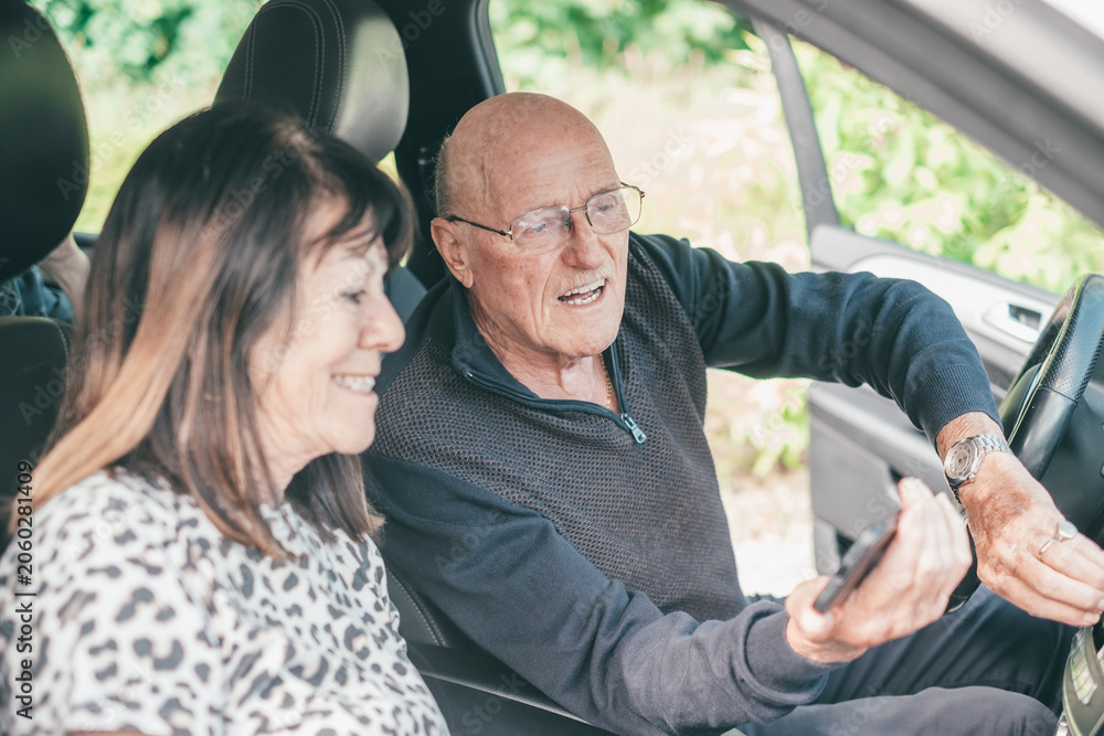 Fototapeta premium Senior couple using smartphone for navigation in car
