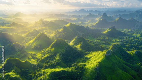 Expansive aerial view of lush green mountain ranges bathed in golden sunlight, a majestic natural landscape